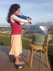 Student outdoors studying and playing violin