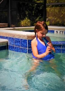 Oak Meadow student playing recorder in the pool