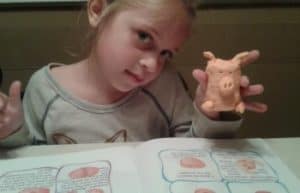 young student holding up a pig