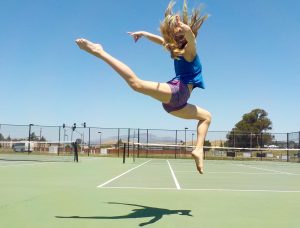 Student dancing on a tennis court