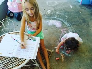 Two students drawing outside