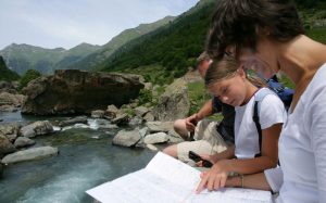 Oak Meadow family studying map by a river