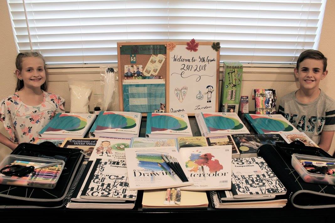 grade 5 students with their Oak Meadow homeschool curriculum laid out on table