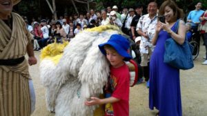 Boy carrying bundle of wool at festival
