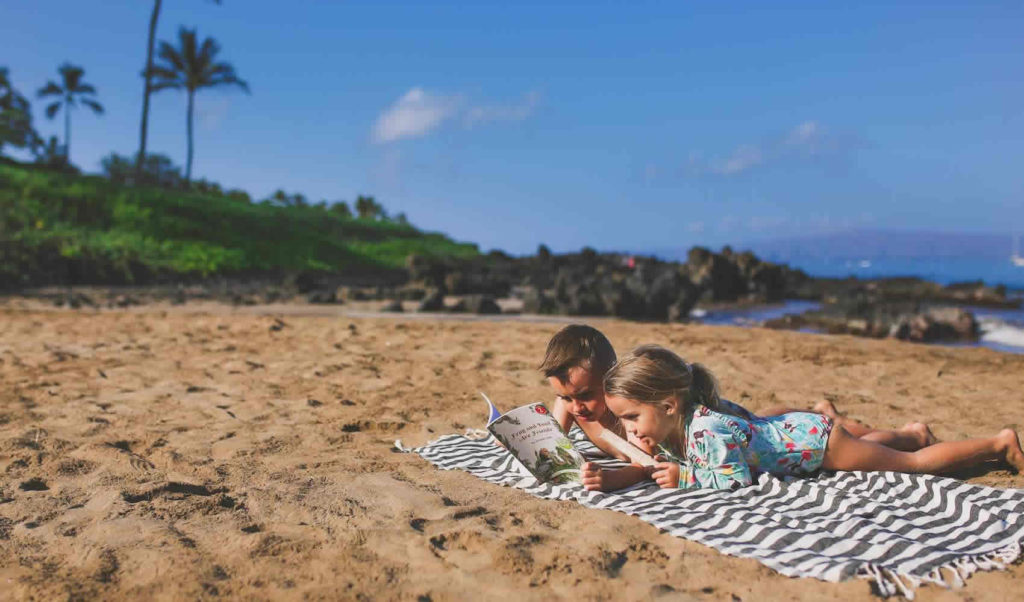 Student reading on beach