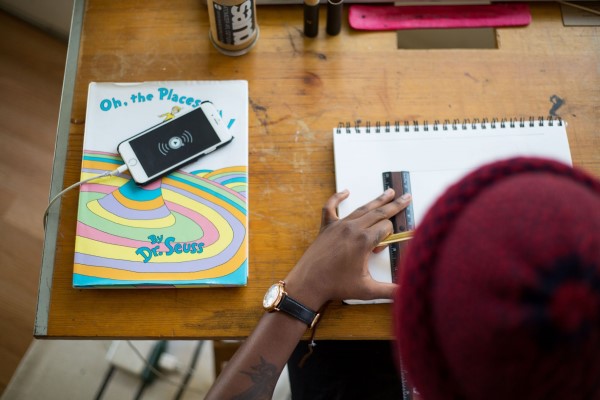 Student in a hat using a ruler with Dr. Seuss's Oh The Places You'll Go