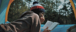 homeschool student reading outdoors in a tent