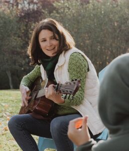 Shannon Miller - Oak Meadow K-8 Director, playing the guitar