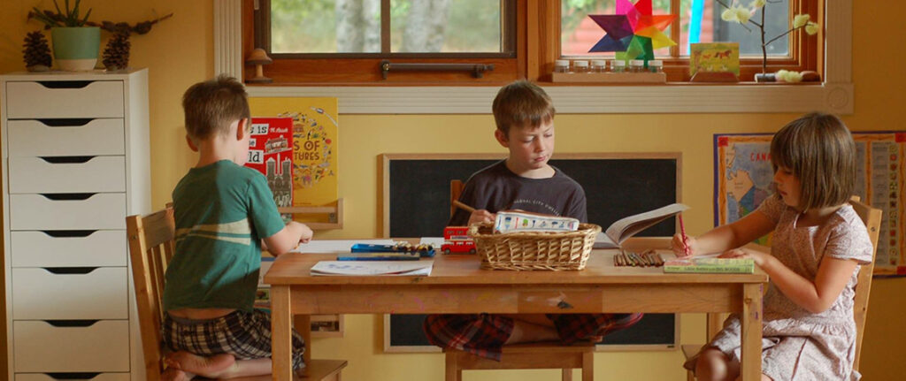 three students working at their homeschool space