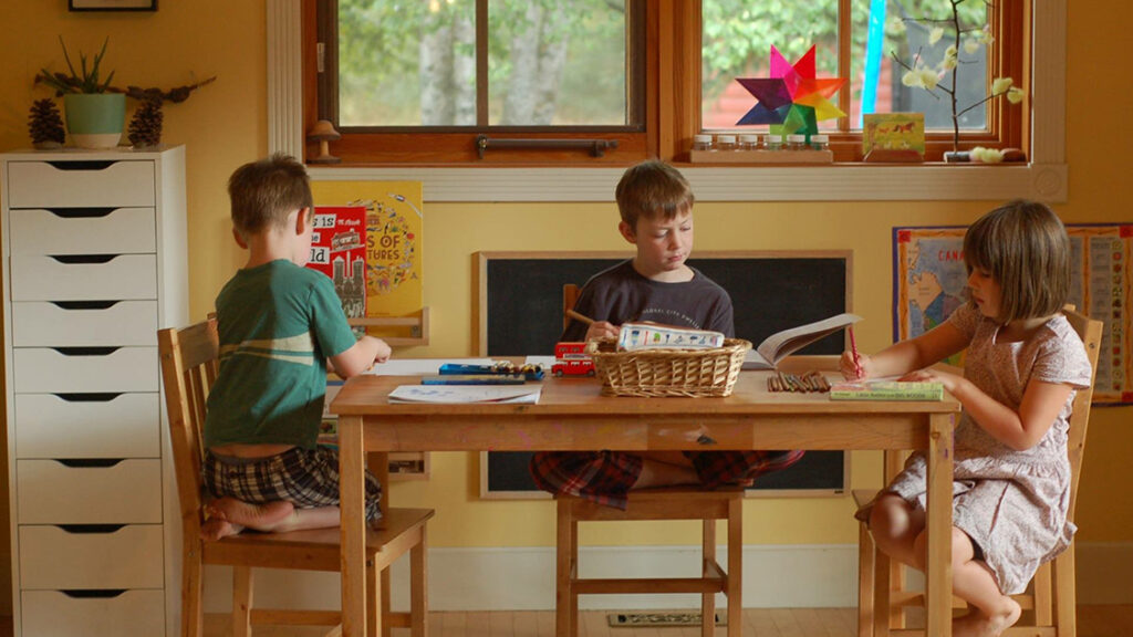 three students working at their homeschool space