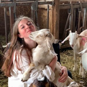 Diana Wipf in a barn with many goats
