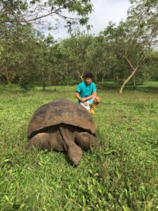 Jack D'Souza in the Galapagos with a tortoise 