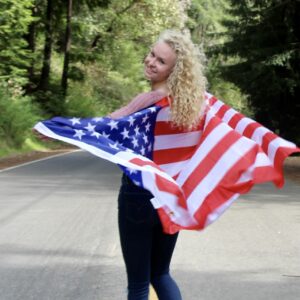 Jaden Olauson with an American flag draped over her shoulders