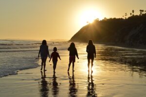 Megan Frederick and family walking on the beach at sunset