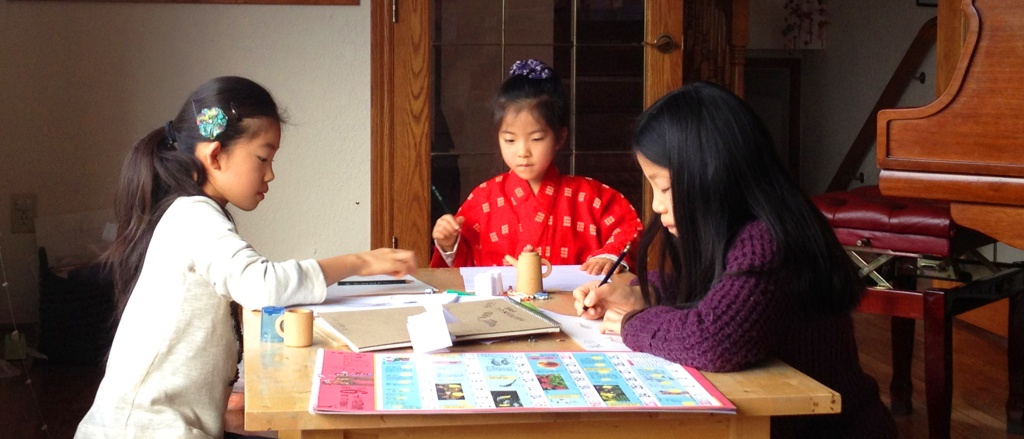 three students working together at a desk