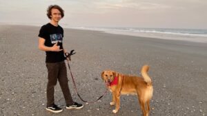 Michael Lautenbach walking dog on the beach