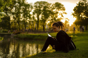 Oak Meadow homeschool student reading by a lake
