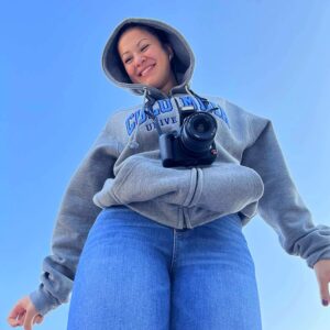 Samantha Bean wearing a hoodie with her camera