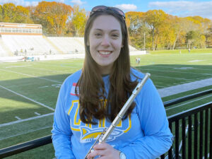 Zoe Meredith holding a flute by a football stadium